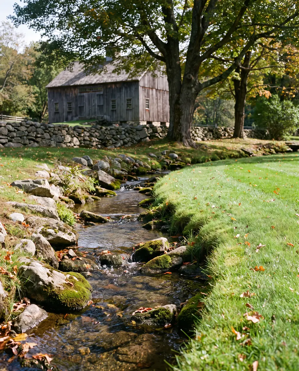 Small rocky brook next to a neatly trimmed lawn edge in rural Connecticut